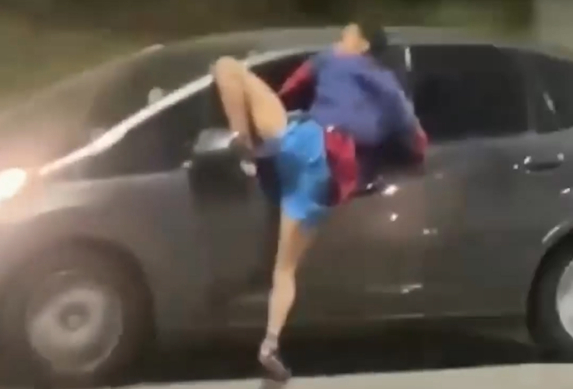 Vídeo mostra indivíduo preso em janela de carro após suposta tentativa de roubo